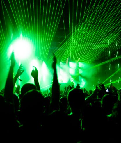 back-view-audience-with-arms-raised-front-stage-music-concert